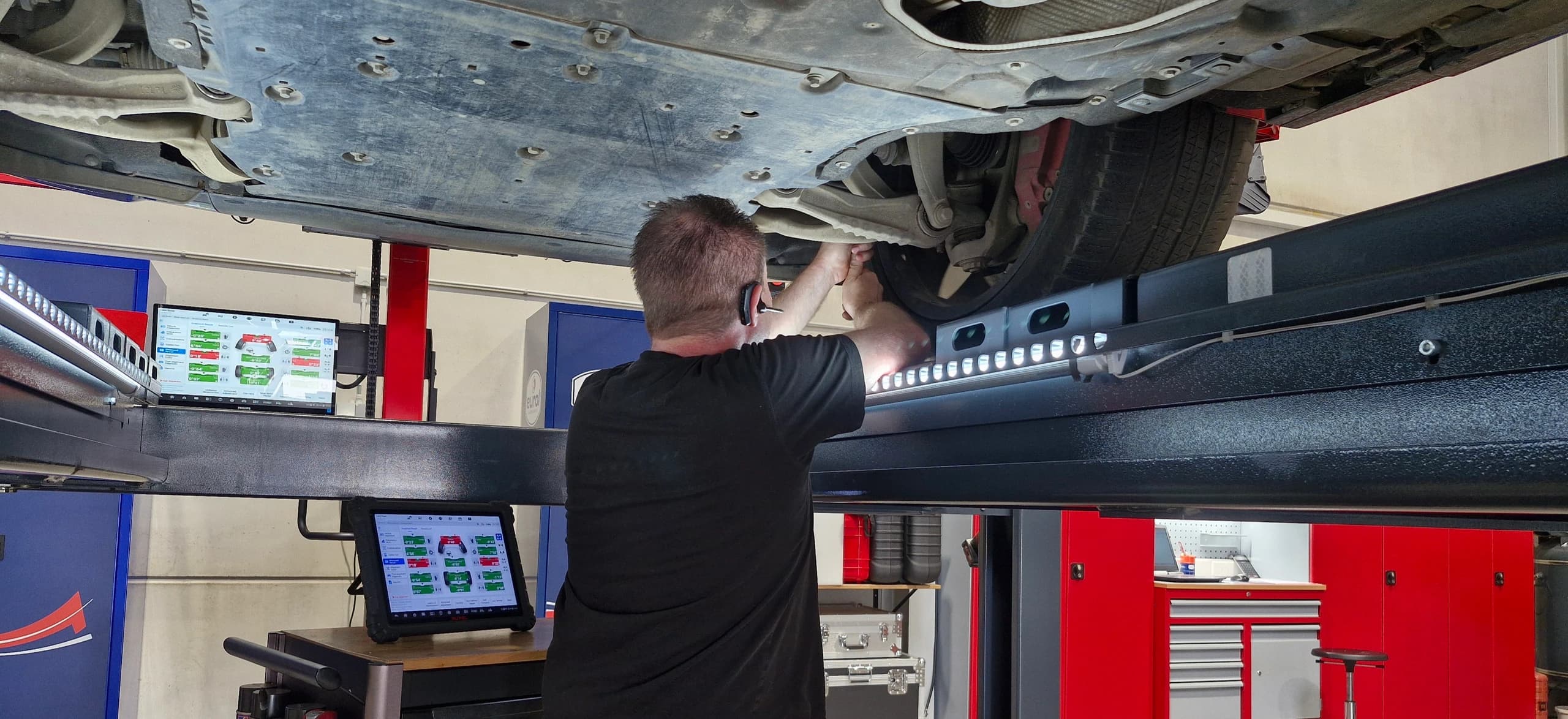 Werkplaats van Leusch met de wagen op de uitlijnbrug